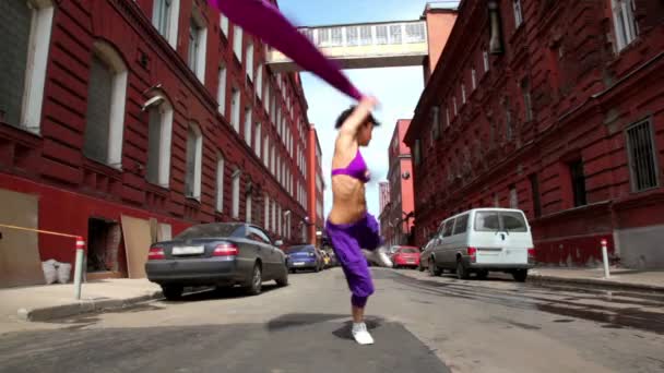 Fille danse dans un style moderne avec tissu sur la rue — Video