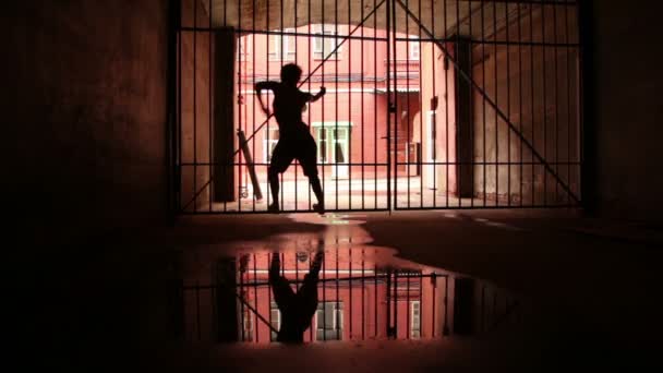 Молода жінка рухається, стоячи на ґраткових воротах — стокове відео