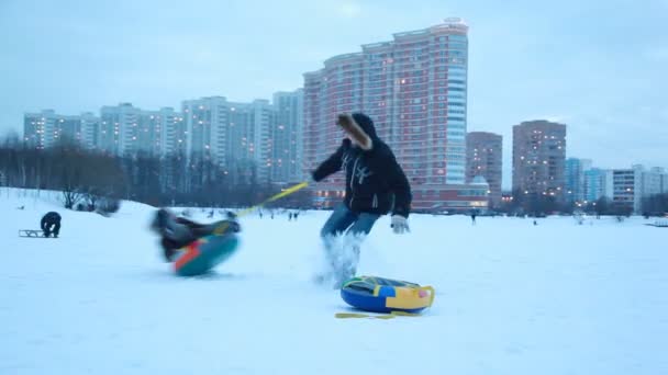 The adult boy spins the sled around in the winter — Stock Video