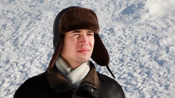 Face of a young man in earflaps who looking and smiling — Stock Video