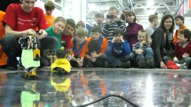 Děti sledovat boj mezi dvěma roboty během robofest-2011 — Stock video