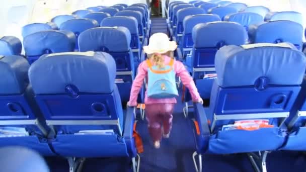 Little girl in pink suit and white hat walks in salon of Aeroflot airbus A320 — Stock Video