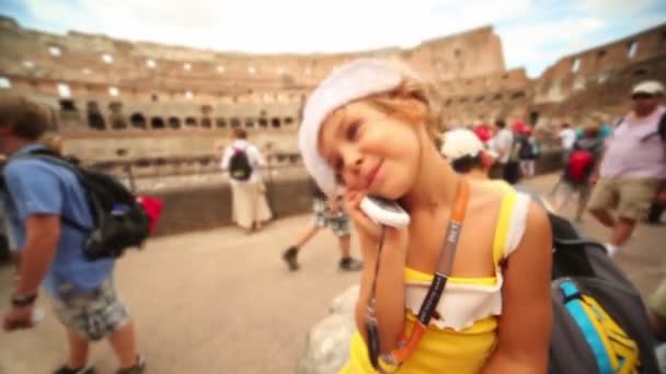 Chica quedarse en Coliseo con el teléfono celular cerca de oreja — Stockvideo