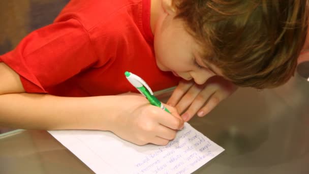 Top view of boy writes something. — Stock Video