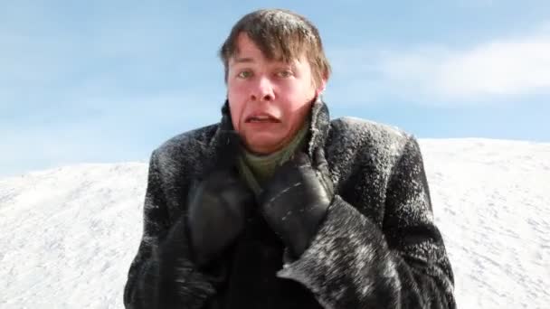 The man all in snow is shivering, seems that he was cold — Stock Video
