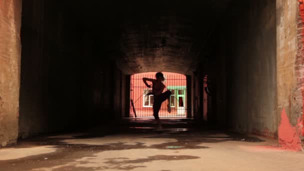 Woman dances modern style in front of gate lattice — Stock Video