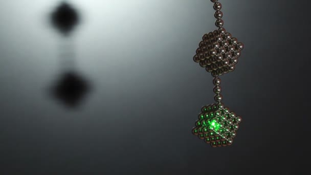 Ray of laser light on cube compound of magnet spheres — Stock Video