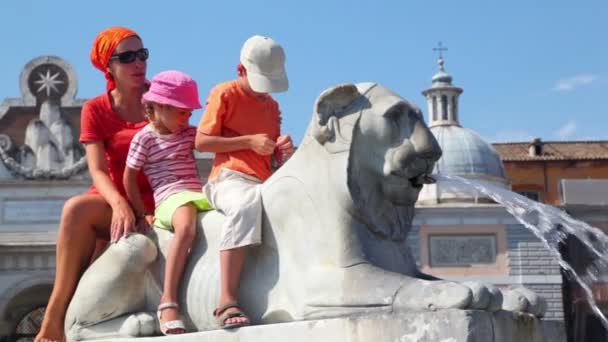 Mother and her kids sit on statue of lion near Flaminio obelisk — Stock Video