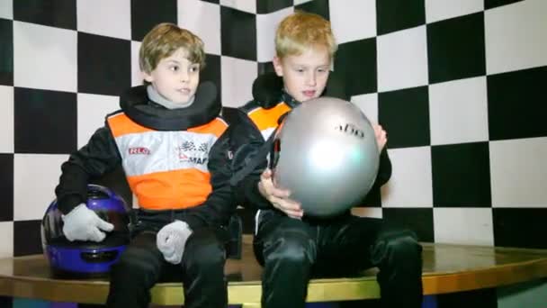 Meninos sentar-se em uniforme para go-cart corridas e esperar o início das corridas — Vídeo de Stock