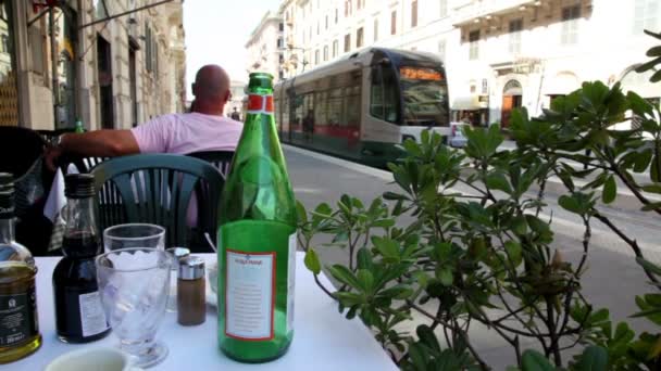 Tram arrives at the station and people come out of it, view from cafe table — Stock Video