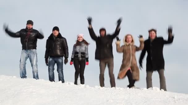 Un gruppo di giovani ride sul pendio con la neve — Video Stock