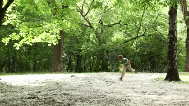 Boy runs closer across forest meadow all strewn fluff — Stock Video