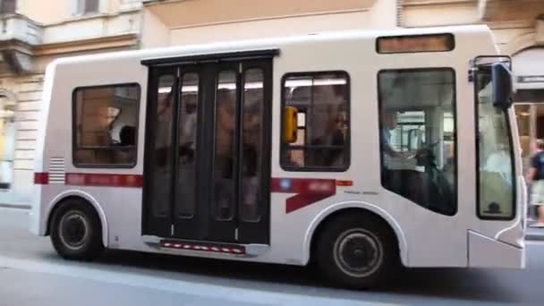 Bonito autobús blanco paseando por la calle estrecha en el centro de la ciudad — Vídeos de Stock