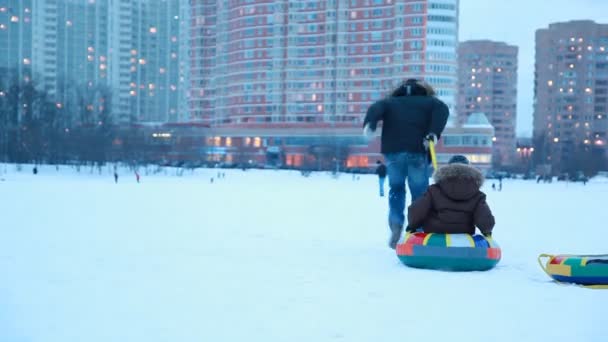 成人的男孩快速与其他男孩拉雪橇 — 图库视频影像