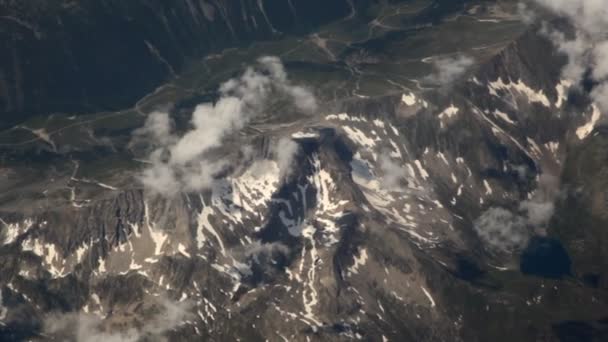 View on landscape of mountains and clouds from window of flying plane — Stock Video