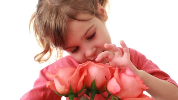 Little girl touches beautiful pink roses in bouquet and says something — Stock Video