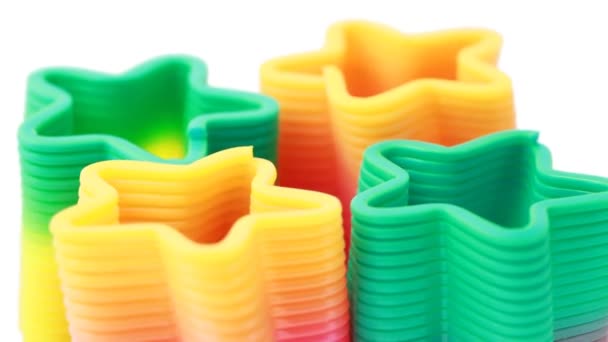 Quattro giocattoli-molle di plastica in forma stelle ruotano — Video Stock