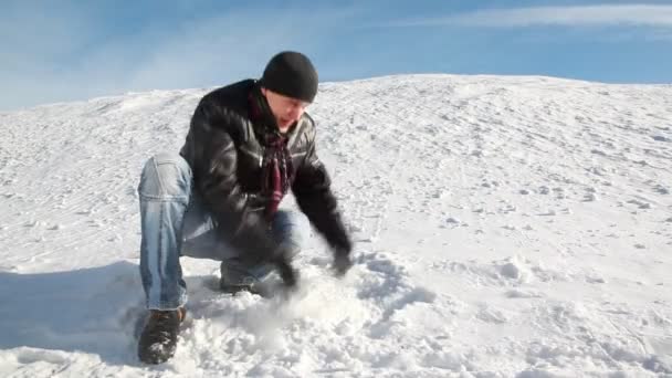 男が座っているとの雪を投げる — ストック動画