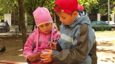 küçük kız ve erkek birlikte oturup dergi izle