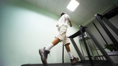 adam yakınındaki duvara spor salonunda koşu bandı üzerinde çalışan