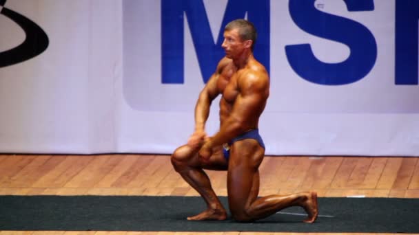 Bodybuilder poses on stage at Open Cup of bodybuilding of Moscow — Wideo stockowe