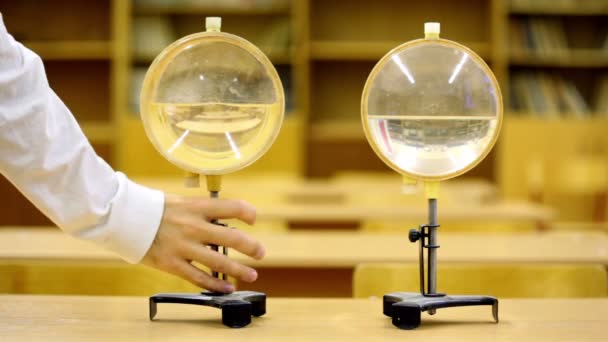 Водні лінзи для освітніх експериментів з фізики, людина прийшла і взяла один — стокове відео