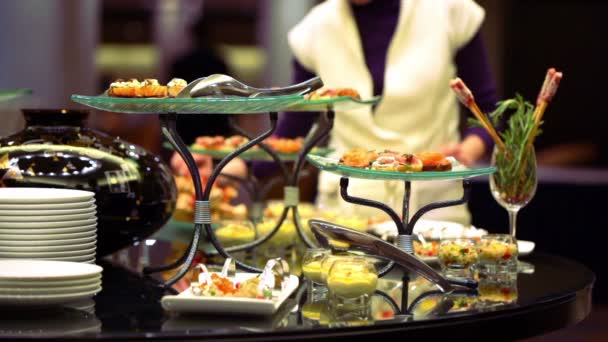 穿白衣服的女人采取一些食物从单口相声餐表 — 图库视频影像