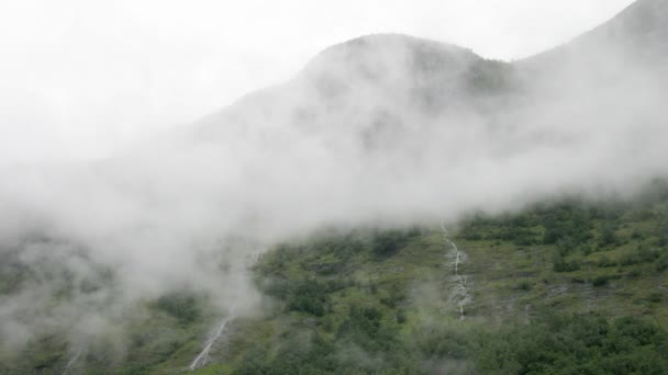 Маленькие водопады в тумане покрытые горами — стоковое видео