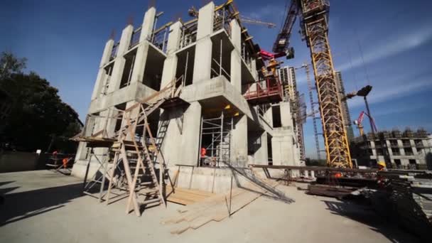 Málo stavitelé obejít malé nedokončená stavba — Stock video