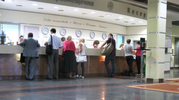 Mensen verlaten en komen bij de receptie in hotel izmajlovsky — Stockvideo