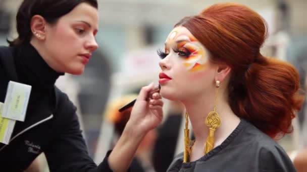 Visagiste makes makeup for red head model at XVII International Festival World of Beauty 2010 — Stock Video