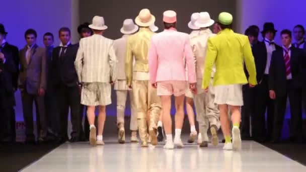 Сзади мужчины носят светлые костюмы от Славы Зайцева ходить по подиуму — стоковое видео