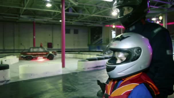 Junge und Trainer in Rennhelmen beobachten Kart-Fahrt — Stockvideo