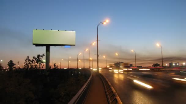 Große weiße Werbetafel am Straßenrand, Autos fahren schnell auf die Autobahn — Stockvideo