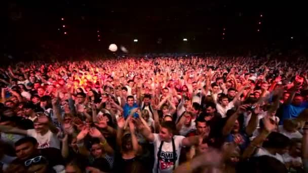 As pessoas levantam as mãos na festa rave em grande salão — Vídeo de Stock