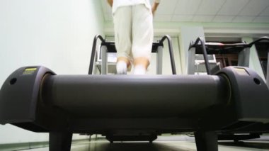 boş spor salonunda treadmill çalışan adamın ayakları