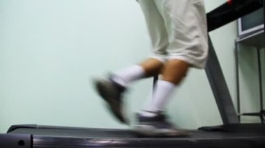 Adamın bacakları yakınındaki duvara spor salonunda treadmill çalıştırın.