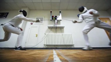 Boy and girl fence with swords at club Dynamo
