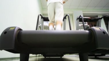 Adamın bacakları hemen boş spor salonunda treadmill çalışan.