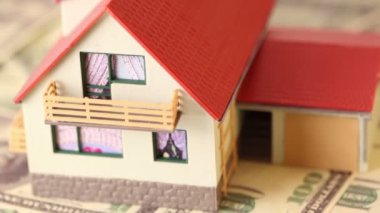 Kırmızı kiremitli çatıya dolar banka notları ile oyuncak ev
