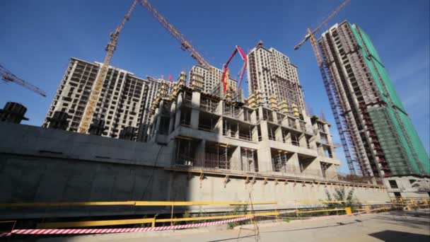 Tour de benne rouge sur la route devant le chantier de construction de maisons — Video