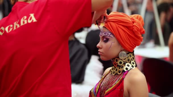 Visagiste κάνει το μακιγιάζ για το μοντέλο που φορούν τουρμπάνι Άραβας σε διεθνή φεστιβάλ κόσμο xvii της ομορφιάς 2010 — Αρχείο Βίντεο
