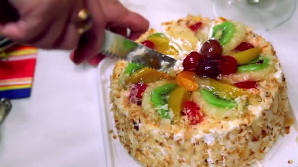 Hands severs sweet fruit cake by knife — Stock Video