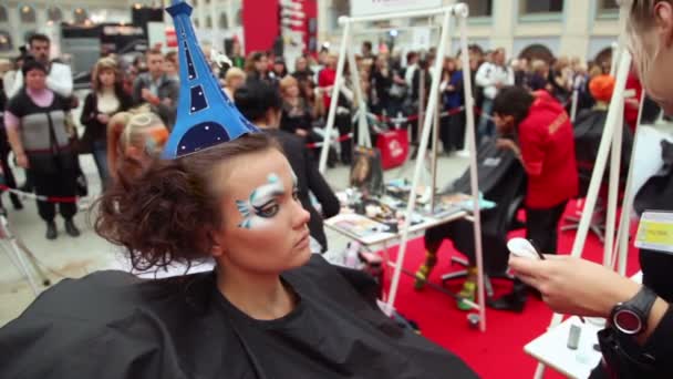 Visagiste makes body art for model with hat as Eiffel Tower at XVII International Festival World of Beauty 2010 — Stock Video