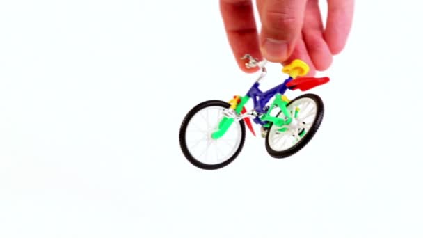 La mano salta con il trucco della pendenza sulla bicicletta giocattolo e se ne va, quindi ripete dall'altro lato — Video Stock