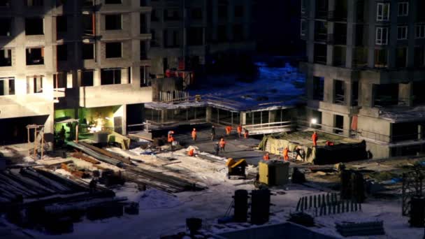 Arbeiders werken op bouwterrein op winternacht — Stockvideo