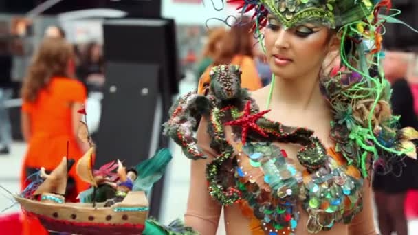 Модель носить платье из водорослей и держать игрушечный корабль — стоковое видео