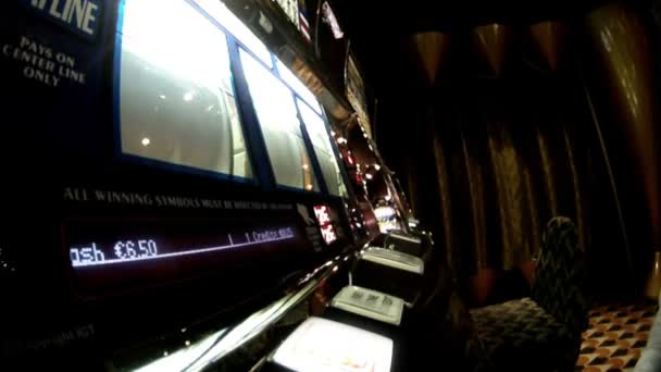 Человек сидит за игровым автоматом и нажимает на кнопку — стоковое видео