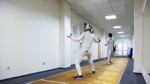 Boy and girl fence with swords on special carpet — Stock Video