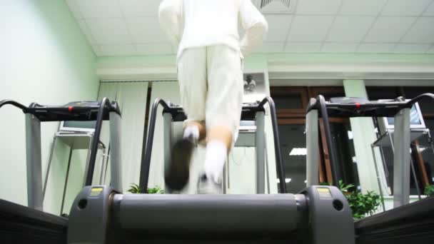 Man runs on treadmill in large empty gym — Stock Video